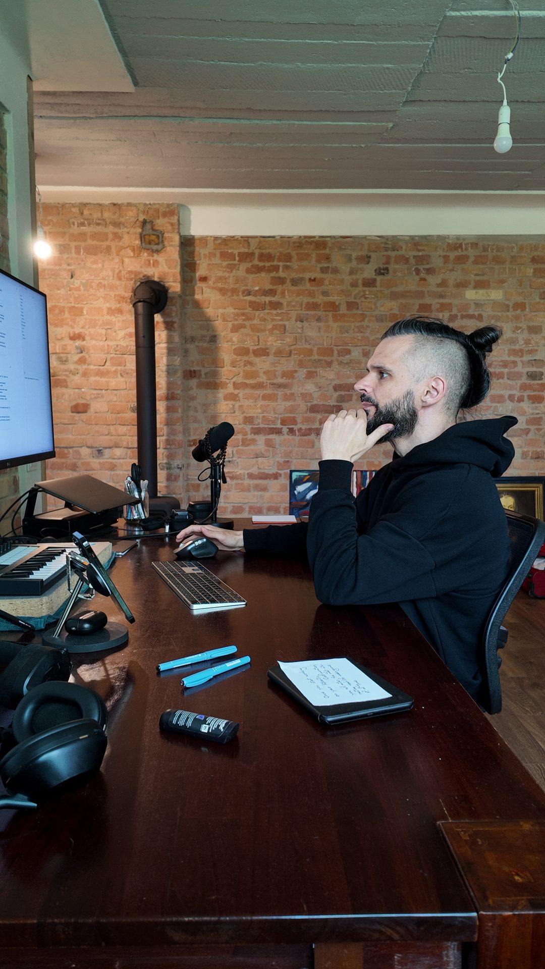 Lee at the desk, hand to his chin, studying the screen.